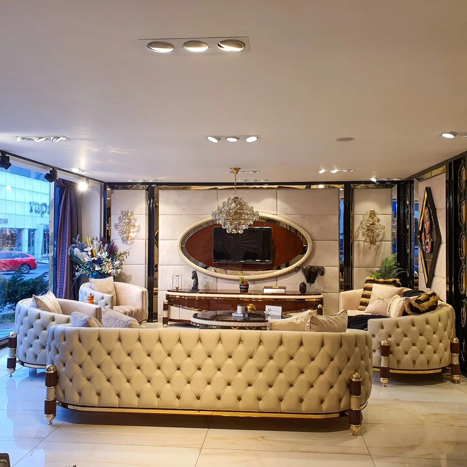 Tufted ivory sofas and a round table on the gilded floor of the Arche Baku showroom